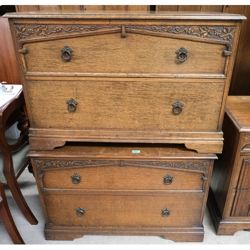 873 - A pair of low carved oak two height chests of drawers with scrolling grape and vine decoration.