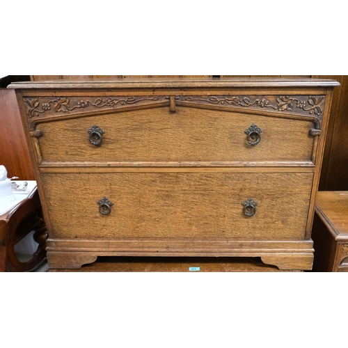 873 - A pair of low carved oak two height chests of drawers with scrolling grape and vine decoration.