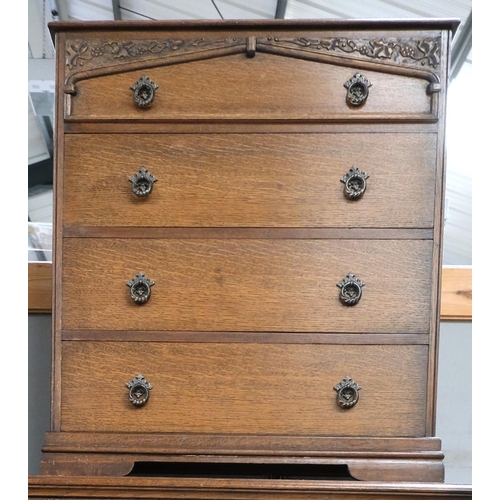 874 - An oak carved two piece bedroom set comprising oak chest of four drawers and a two door wardrobe wit... 