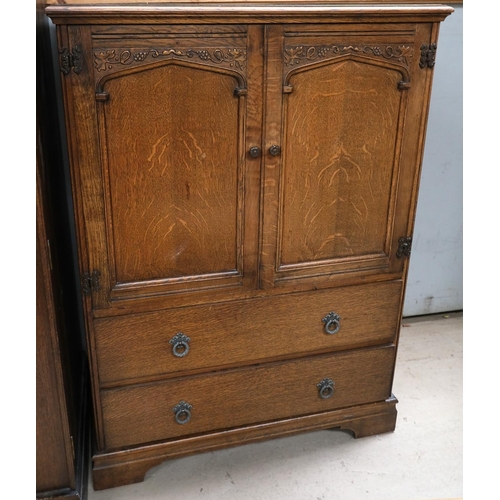 876 - A carved oak tallboy with double doors above and drawers below, and grape and vine decoration.