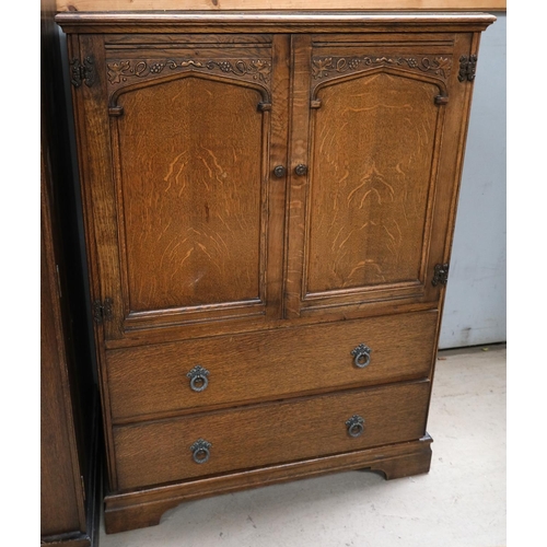 876 - A carved oak tallboy with double doors above and drawers below, and grape and vine decoration.