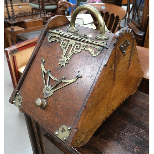 896 - An Asthetic movement oak coal scuttle with brass bindings and decoration, with shoval