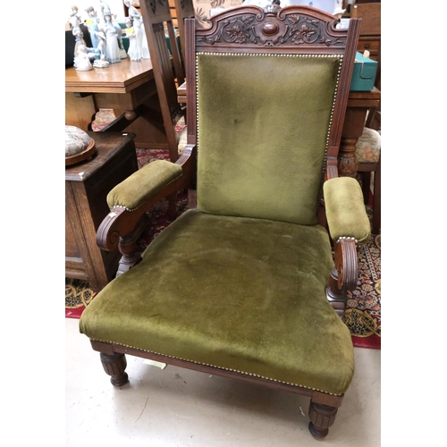 907 - An Edwardian mahogany armchair with carved crest and turned legs in studded olive green velvet.