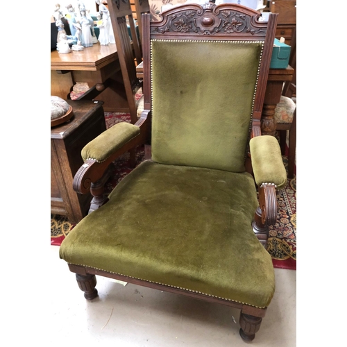 907 - An Edwardian mahogany armchair with carved crest and turned legs in studded olive green velvet.