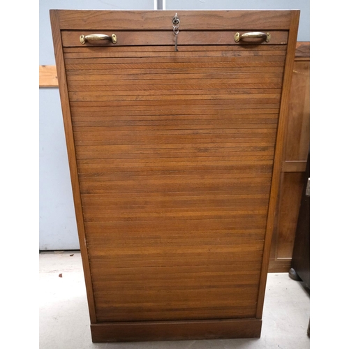 962 - A medium oak office cabinet enclosed by tambour roll front.