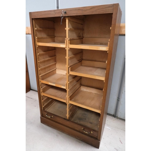 962 - A medium oak office cabinet enclosed by tambour roll front.