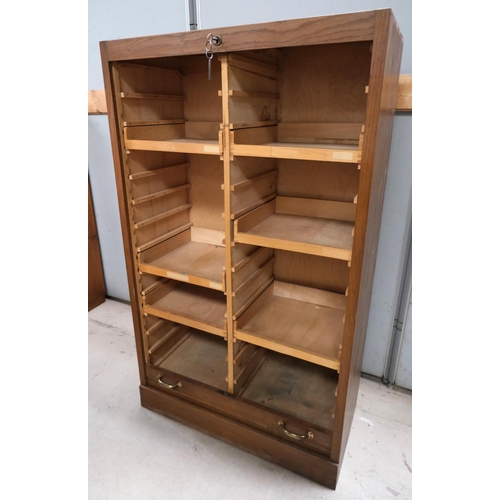 962 - A medium oak office cabinet enclosed by tambour roll front.