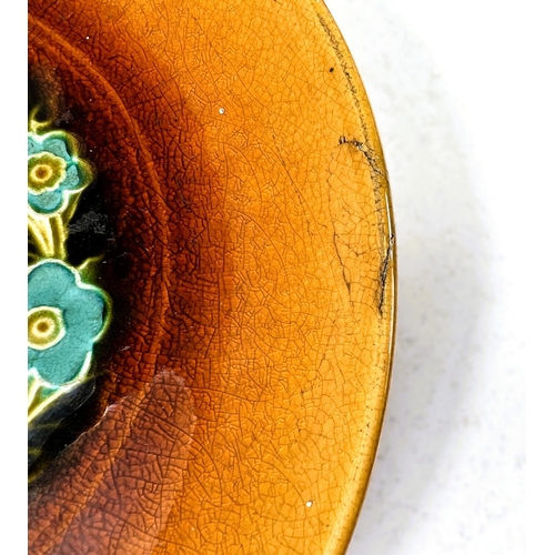 551 - Linthorpe Art Pottery: A shallow dish with multicoloured stylised floral central panel with toffee c... 