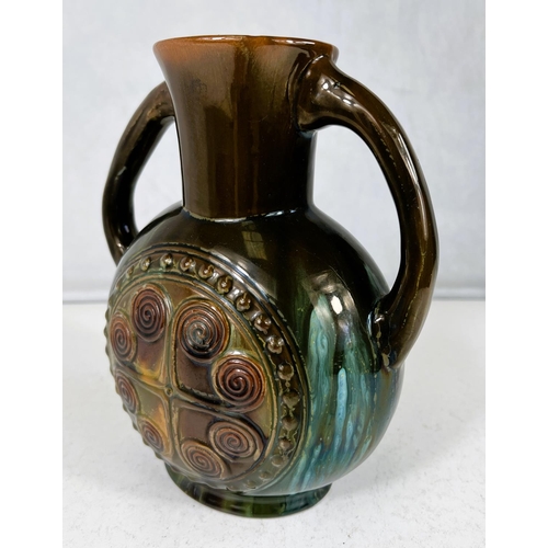 552 - Linthorpe Art Pottery: A flattened circular two handled vase designed by Christopher Dresser, with c... 