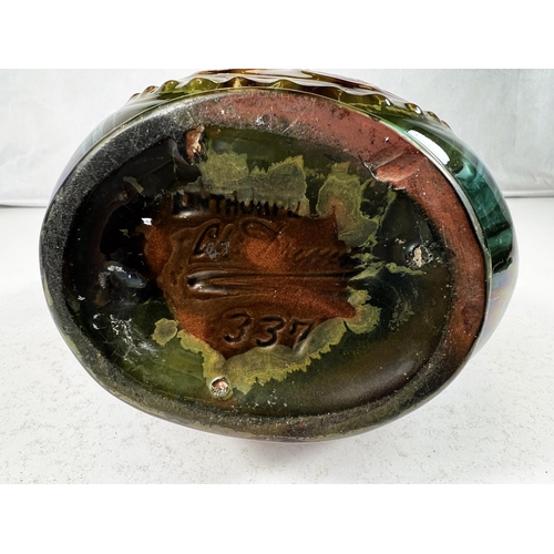 552 - Linthorpe Art Pottery: A flattened circular two handled vase designed by Christopher Dresser, with c... 