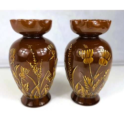 554 - Lindthorpe Art Pottery: - A pair of ovoid vases with wide folded rim, decorated in relief with thist... 