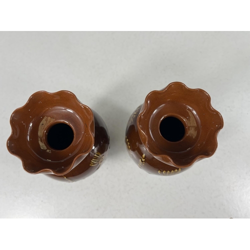 554 - Lindthorpe Art Pottery: - A pair of ovoid vases with wide folded rim, decorated in relief with thist... 