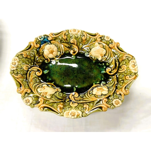 555A - Linthorpe Art Pottery: An oval dish with relief flower and scroll border under yellow/green glaze. I... 