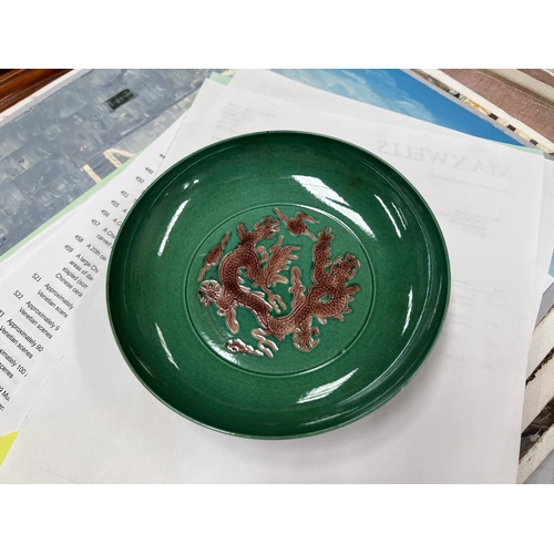 576 - A Chinese green ground glazed dish with central incised dragon in brown glaze with six character mar... 