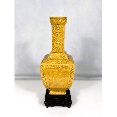 576D - A Chinese yellow glazed vase squared baluster form with relief scrolling decoration including bats e... 