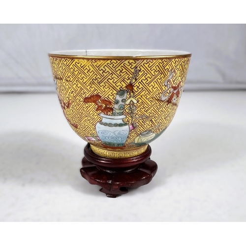 576A - A Chinese yellow ground porcelain cup on stand with red zig-zag pattern with polychrome areas of hig... 