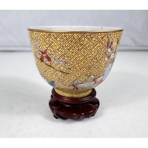 576A - A Chinese yellow ground porcelain cup on stand with red zig-zag pattern with polychrome areas of hig... 