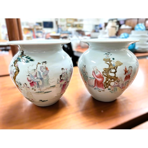 577C - A pair of Chinese vases decorated in polychrome with traditional scenes, squat form with flared rims... 