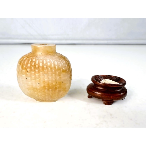 577B - A Chinese jade coloured hard stone snuff bottle with scale light carving to body with small wooden s... 