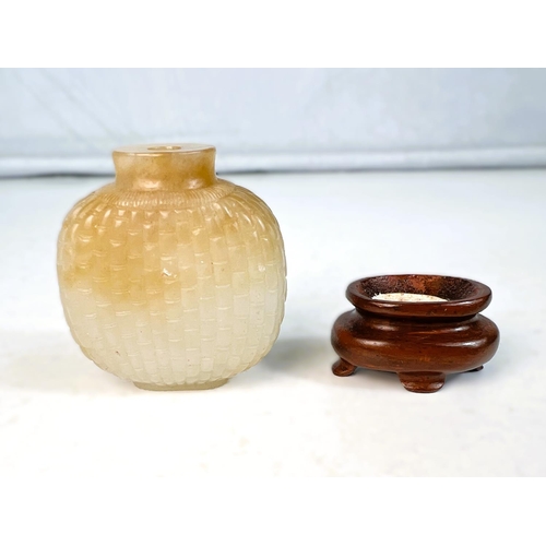 577B - A Chinese jade coloured hard stone snuff bottle with scale light carving to body with small wooden s... 