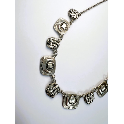 601 - A white metal Scandinavian necklace with alternating links of long boats and Celtic knots; a white m... 