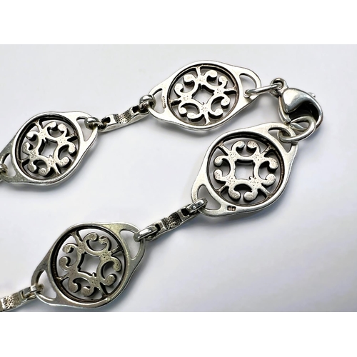 601 - A white metal Scandinavian necklace with alternating links of long boats and Celtic knots; a white m... 