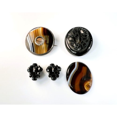 609 - A Victorian jet mourning brooch and earrings; a circular agate brooch and an agate oval plaque.