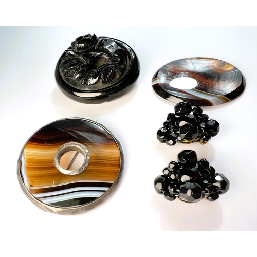 609 - A Victorian jet mourning brooch and earrings; a circular agate brooch and an agate oval plaque.