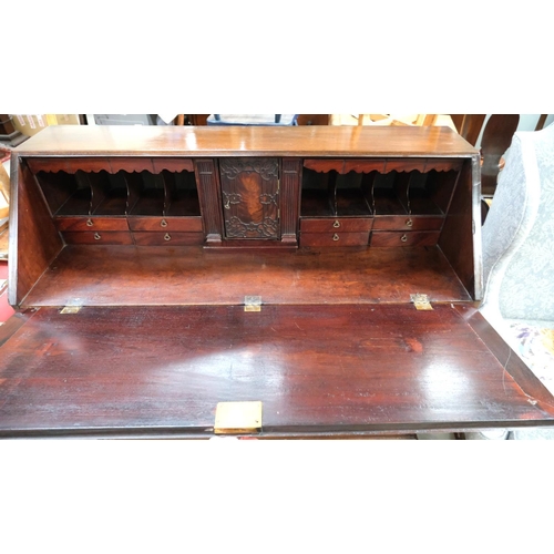 855 - A large Georgian mahogany bureau with decorative interior with secret compartments, three long and t... 