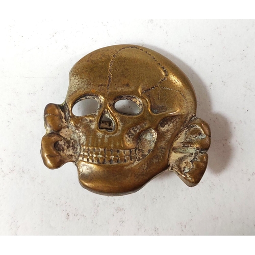 289 - An SS visor cap badge:- Totenkopf (Death Head badge).