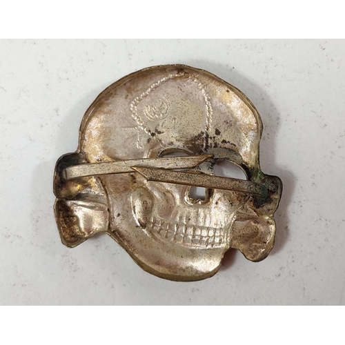 289 - An SS visor cap badge:- Totenkopf (Death Head badge).