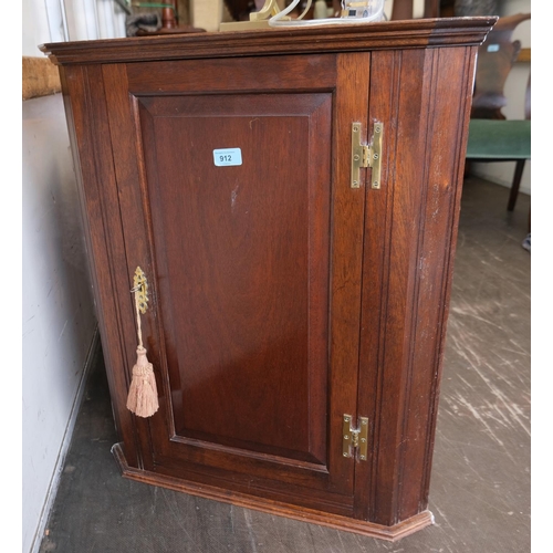 912 - An oak small stature panel front single door corner cupboard 72x59cms.