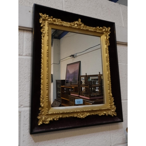 918 - A 19th Century gilt cushion framed mirror with ebonised velvet exterior front decorated with acorns ... 