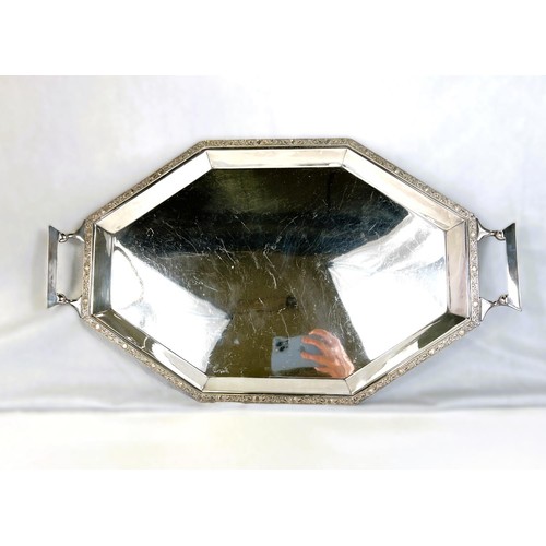 627 - An Art Deco style stretched octagonal two handled silver plated tray with Celtic design border