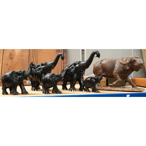 155 - A set of carved ebony wooden elephants graduating sizes five in total and a large carved water buffa... 