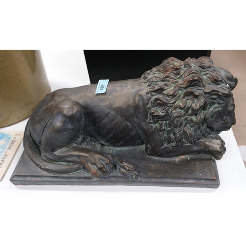 186 - A bronzed figure of a recumbent lion on rectangular base, length 46cm.