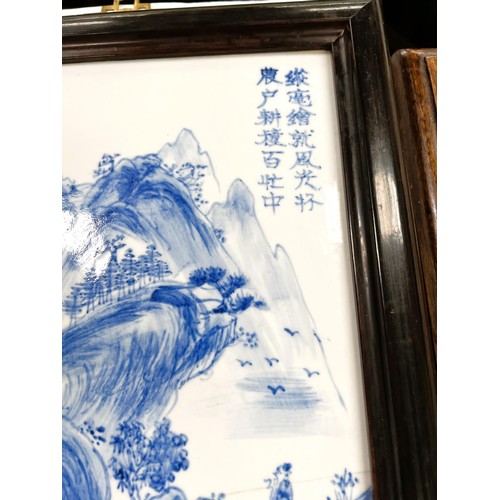 410 - A Chinese framed ceramic blue and white rectangular panel with traditional decoration (crack) and a ... 