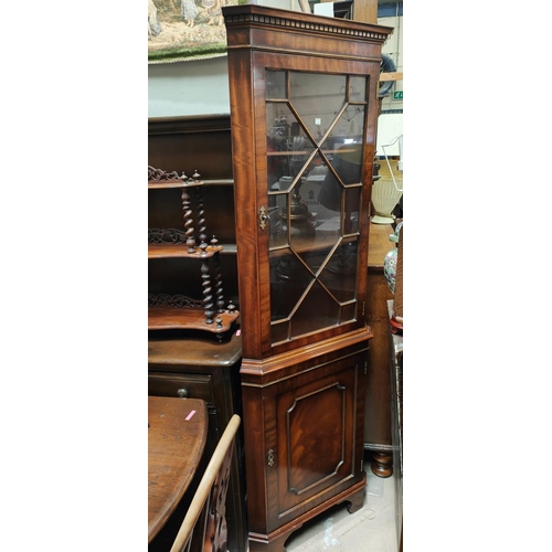 884A - A reproduction full height distressed mahogany corner cabinet.