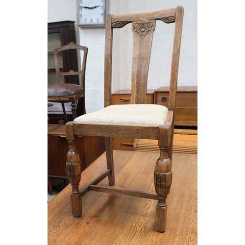 966 - An oak dining table with four matching chairs