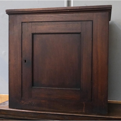 1029 - A mahogany wall hanging cupboard with panel front, height 65x65cm.