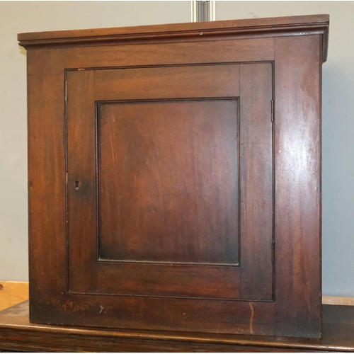 1029 - A mahogany wall hanging cupboard with panel front, height 65x65cm.