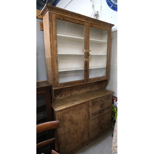 1030 - A large pine farmhouse dresser with double glazed doors above, drawers and cupboard below.