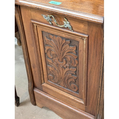 1043 - An Edwardian carved oak fall front coal scuttle with carved panel and brass fittings.