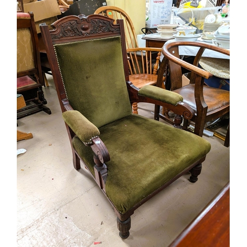 1000 - An Edwardian mahogany armchair with carved crest and turned legs in studded olive green velvet.