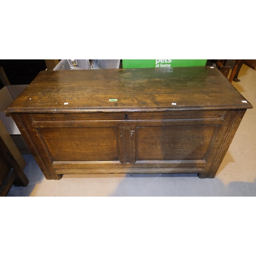 1002 - An 18th Century framed and panelled oak blanket box with hinged lid and block feet, width 117 cm.