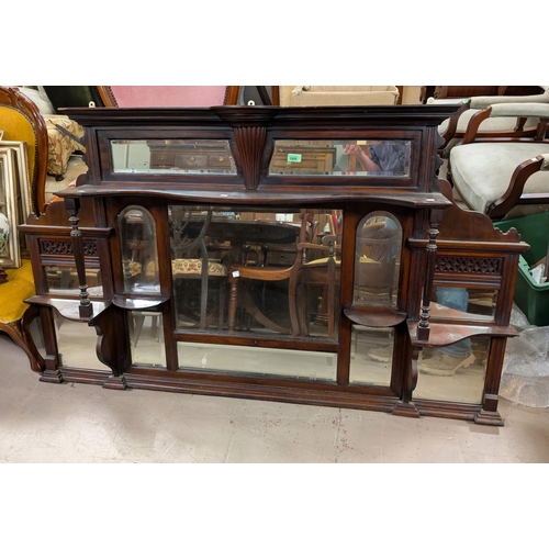 1005 - A Victorian walnut overmantel mirror with bevelled panels and display shelves with turned support pi... 