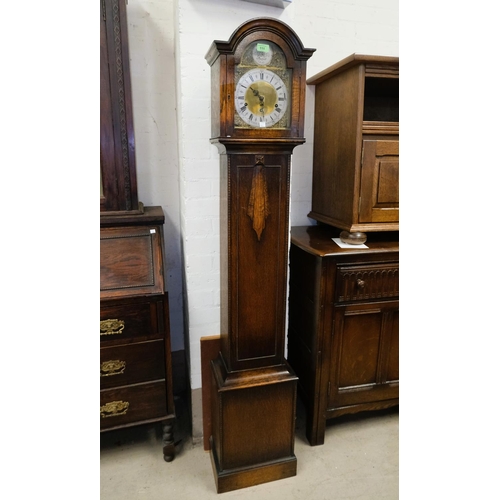 111 - A 1930's oak cased granddaughter clock, Tempis Faucets brass faced dial.