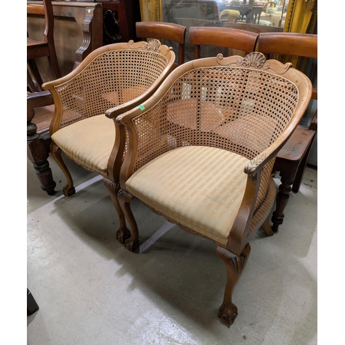 1040 - A pair of French tub arm chairs with carved detail and ball and claw feet.