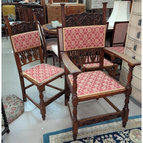 1064 - A set of four (3+1) oak Arts and Crafts chairs with carved grape design on back.