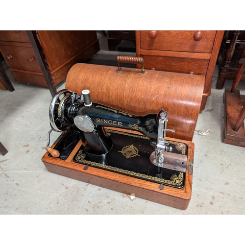 110 - An oak cased Singer sewing machine and accessories. 